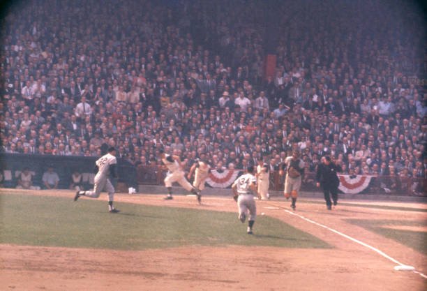 Yankees fielders charge a bunt as Bill Mazeroski runs toward first base during Game 7 of the 1960 World Series