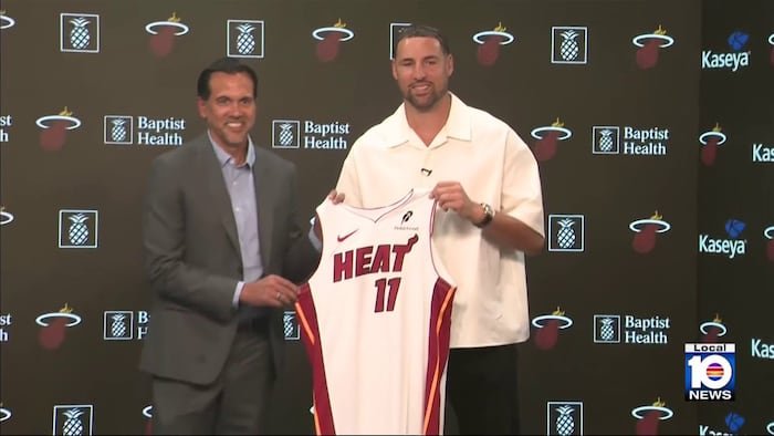 Klay Thompson holds his Miami Heat number 11 jersey beside coach Erik Spoelstra at his introductory press conference