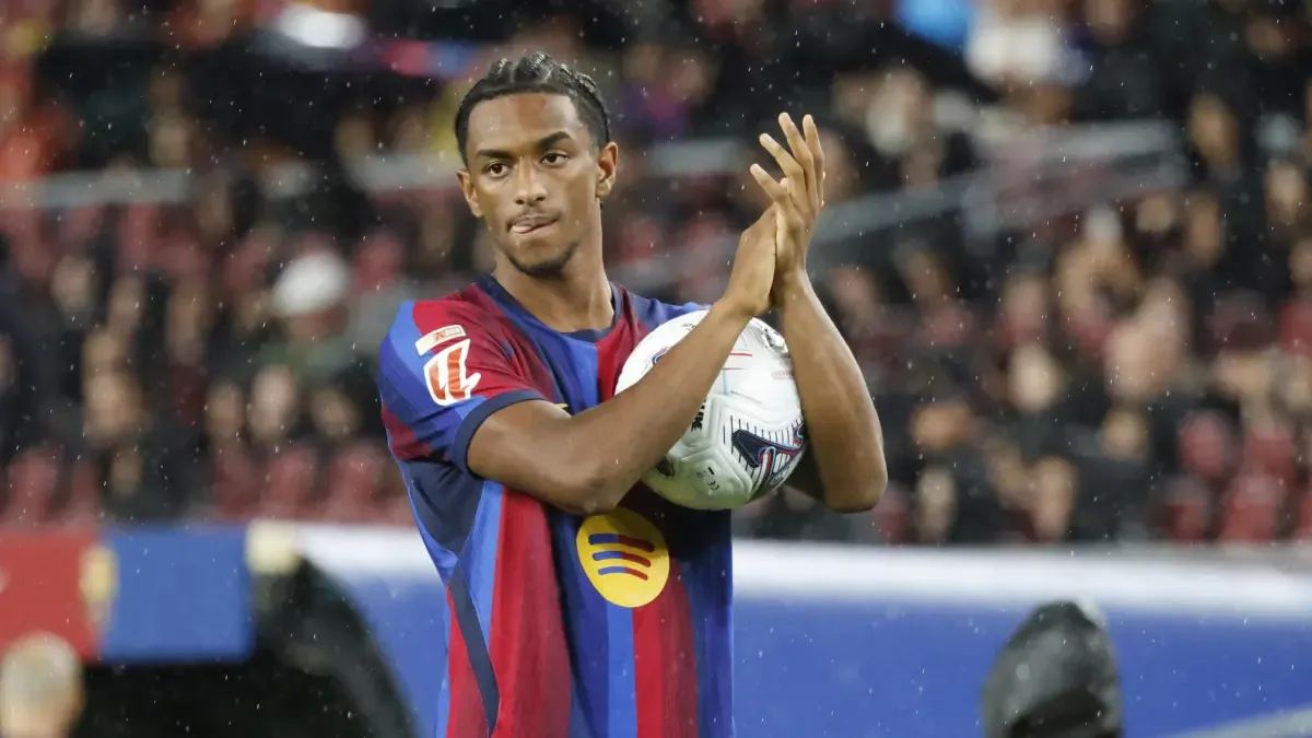 Alejandro Balde applauds while holding a football in Barcelona kit.