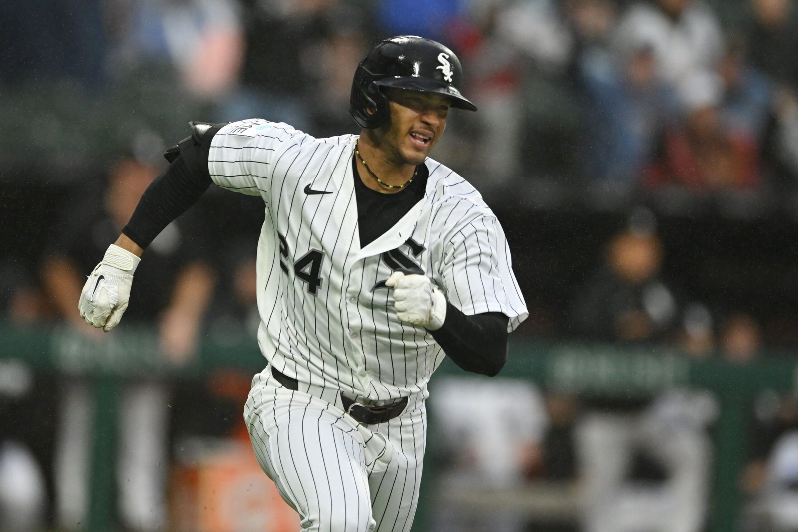 Braden Montgomery runs in a White Sox uniform during a rainy game.