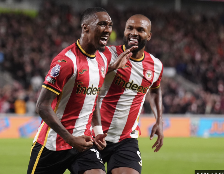 Two Brentford players celebrate on the pitch.