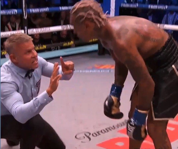Referee Thomas Taylor counts as Conor Benn rises after a knockdown against Ryan Garcia.