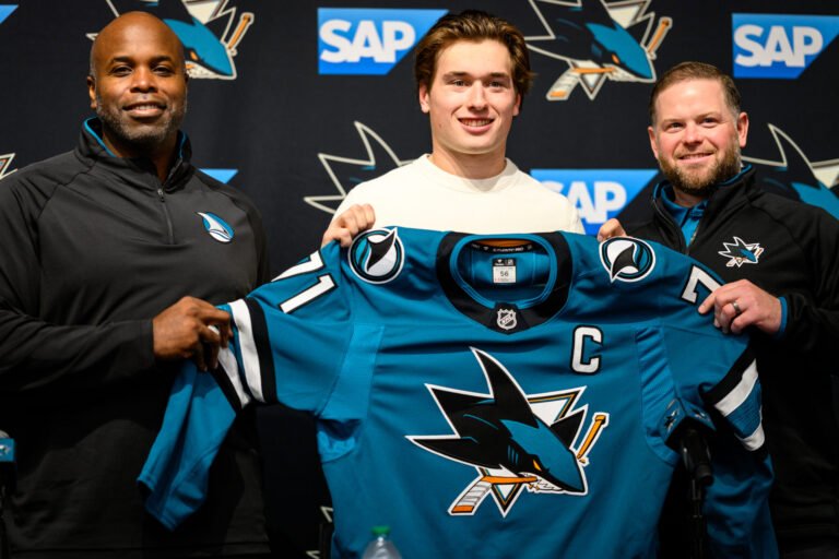 Mike Grier, Macklin Celebrini and Ryan Warsofsky hold Celebrini’s Sharks captain jersey at the September 25 announcement.