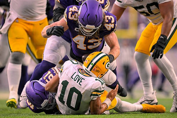 Minnesota Vikings defenders tackle Green Bay Packers quarterback Jordan Love during the Week 1 game in Minneapolis.