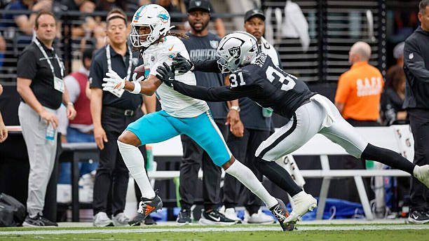 A Miami Dolphins ball carrier is pursued by a Las Vegas Raiders defender during the Week 1 game in Las Vegas.