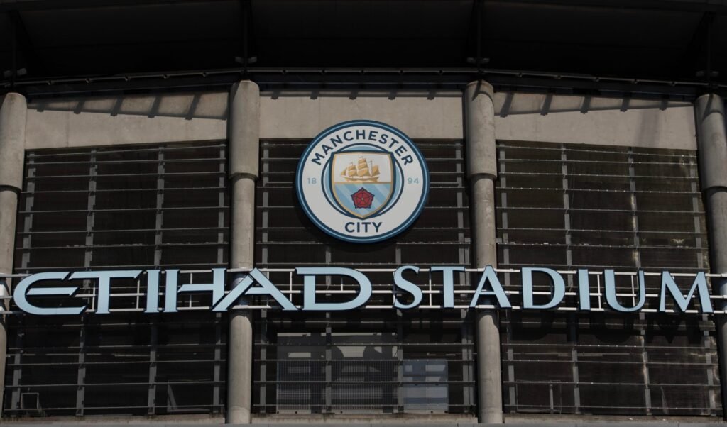 The Manchester City crest above the Etihad Stadium entrance.