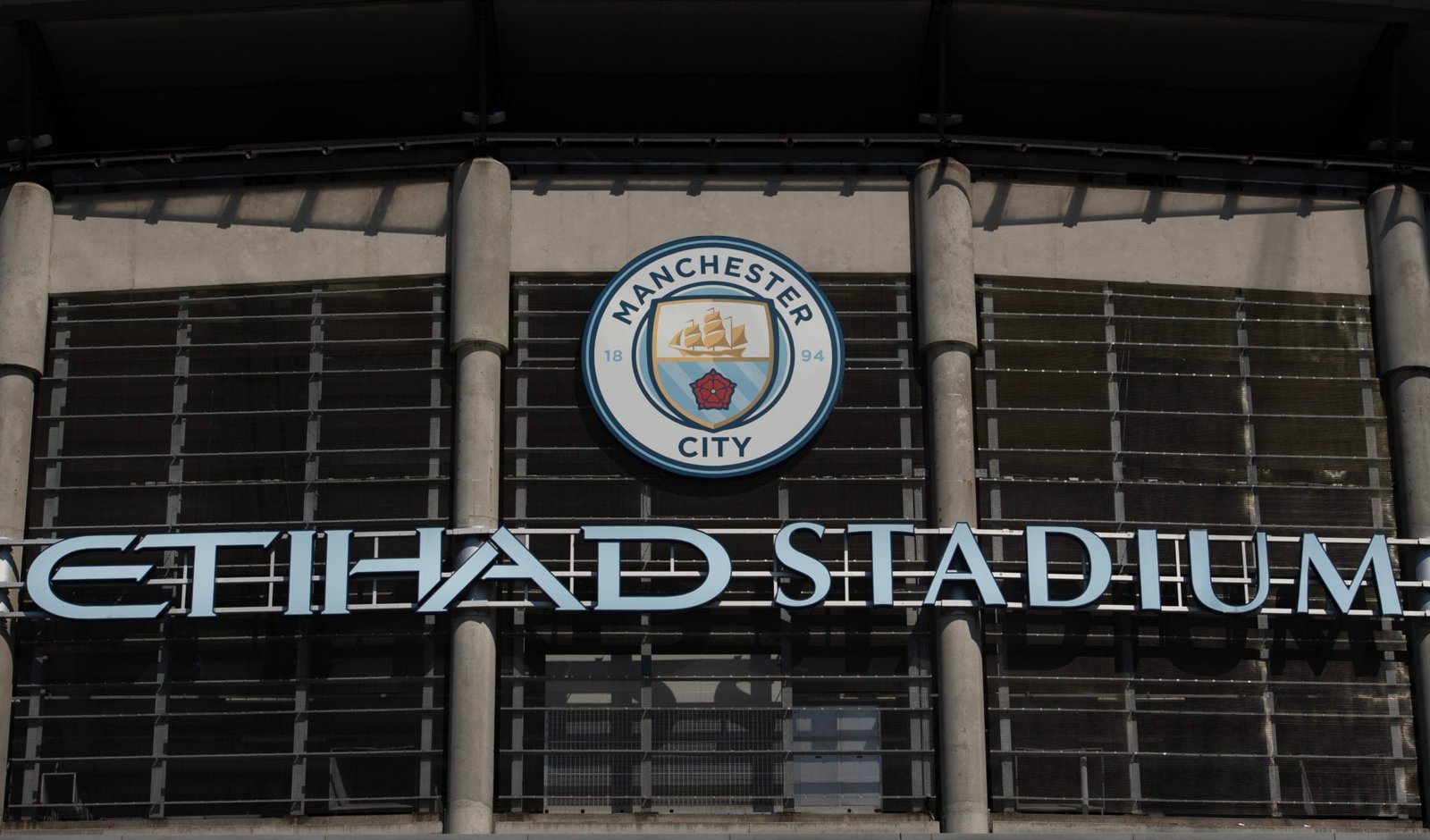 The Manchester City crest above the Etihad Stadium entrance.