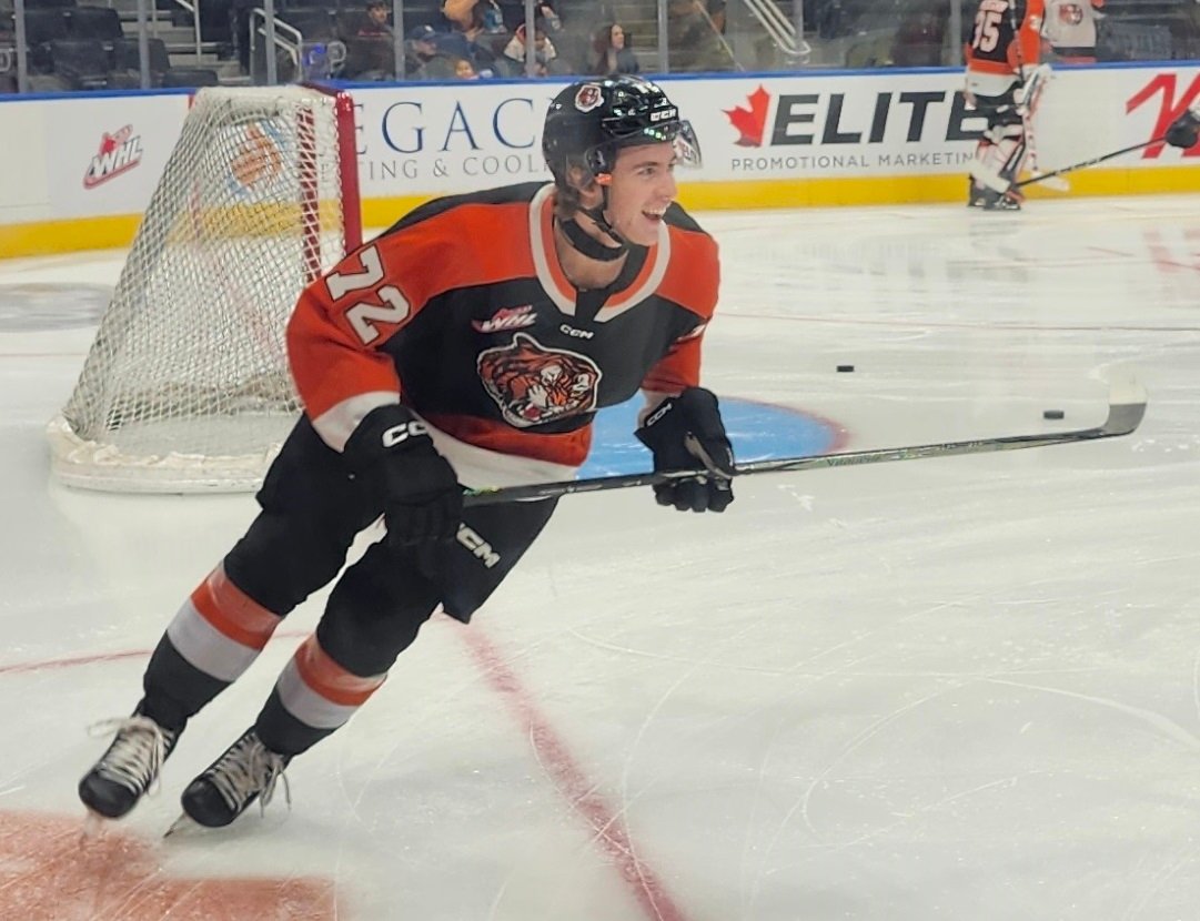 Gavin McKenna wearing number 72 in a Medicine Hat Tigers uniform beside the net.