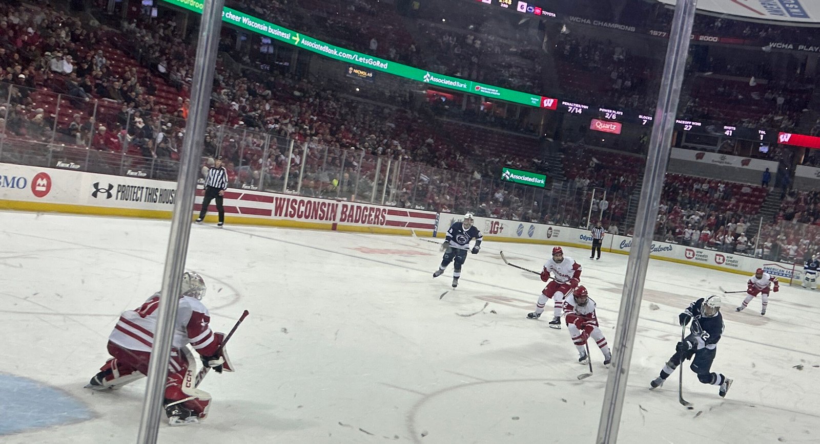 Gavin McKenna, at right in Penn State blue, shoots toward the Wisconsin goal.