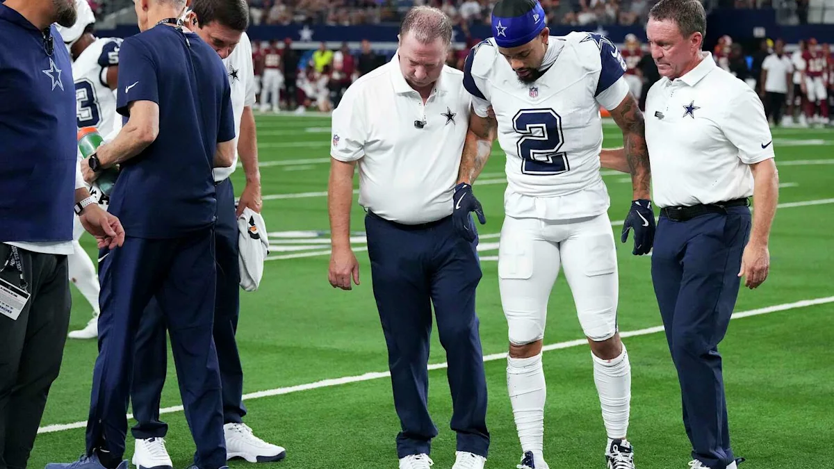Cowboys cornerback Cobie Durant walks off the field with staff after his injury against Washington.