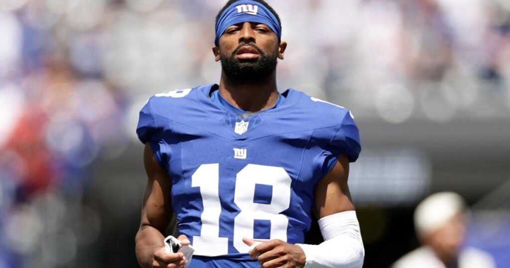 Darius Slayton watches a preseason game while wearing his Giants uniform.