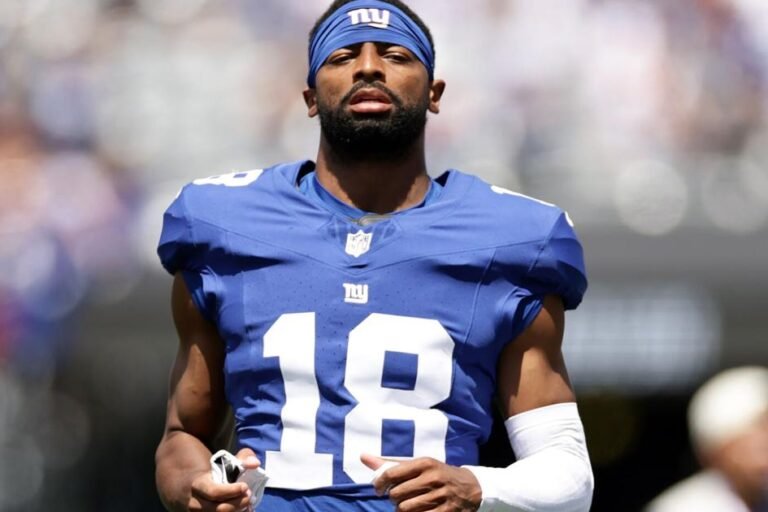 Darius Slayton watches a preseason game while wearing his Giants uniform.