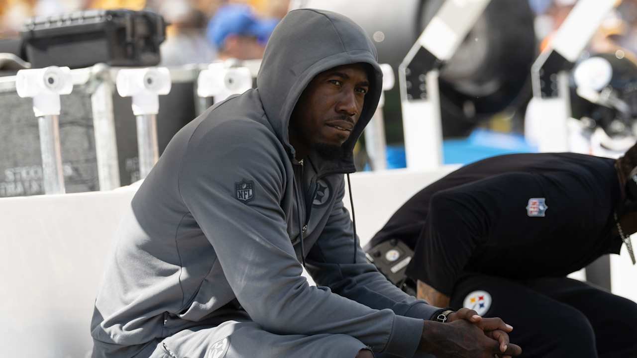 Joey Porter Jr. sits on the Steelers sideline wearing a gray hooded sweatshirt.