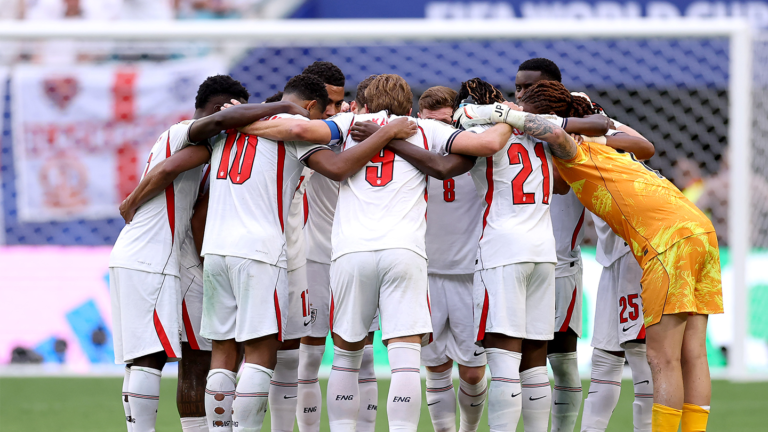 England players gather in a team huddle.
