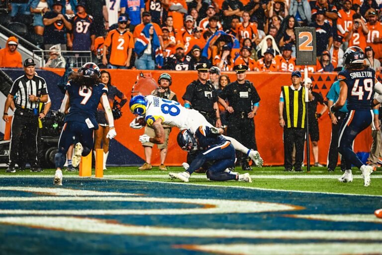 Tyler Higbee dives toward the goal line as Denver defenders tackle him during Rams–Broncos on September 27, 2026.
