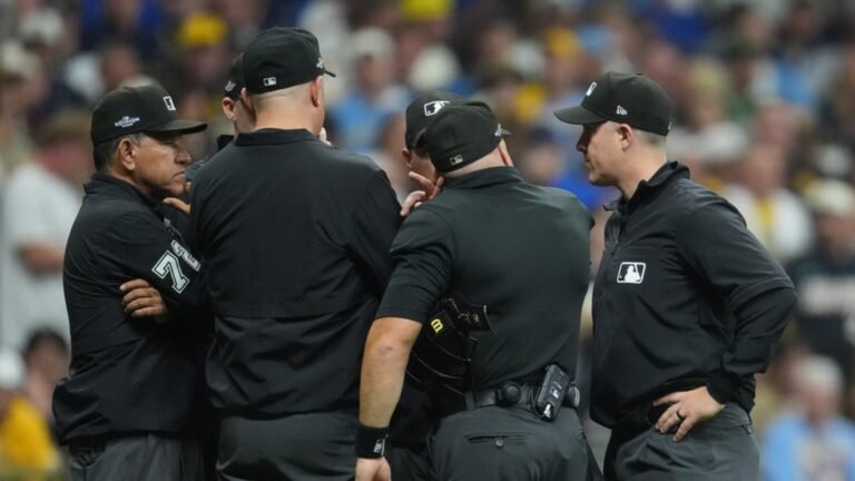 Umpires confer during the review of Ty France’s ninth-inning flyout in Padres–Brewers NLDS Game 1.