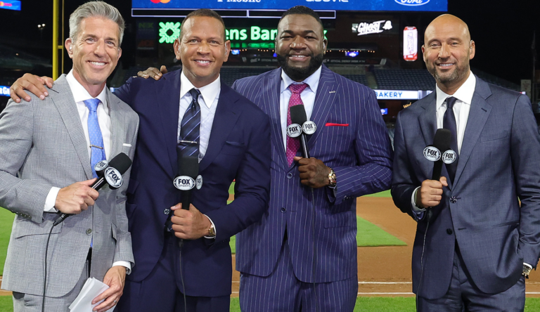 FOX’s MLB studio crew holds microphones at a baseball stadium.