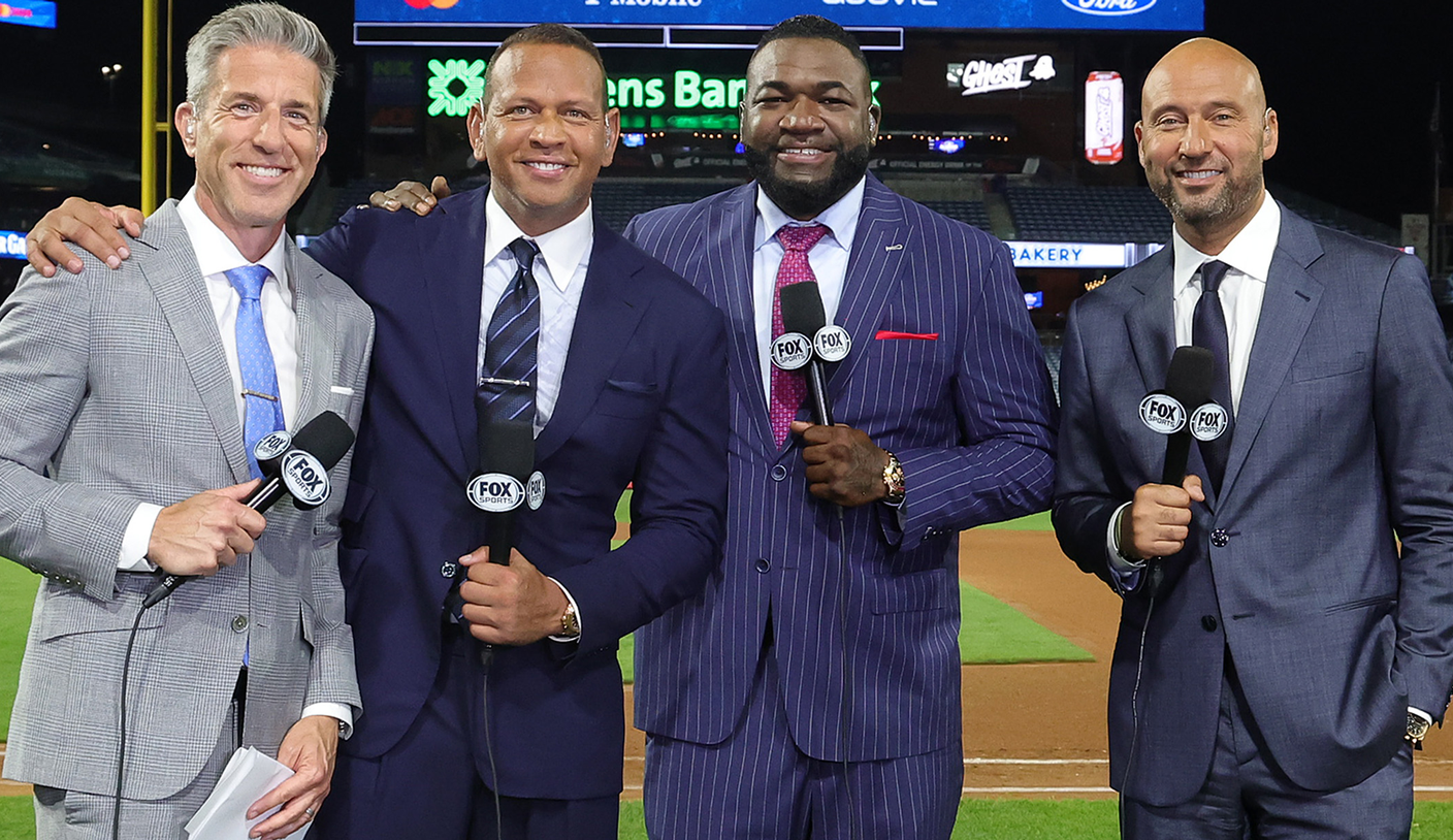 FOX’s MLB studio crew holds microphones at a baseball stadium.