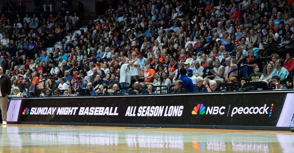 NBC Sunday Night Baseball promotion on a courtside advertising board.