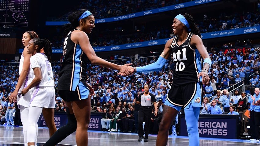 Angel Reese and Rhyne Howard exchange a hand slap in Atlanta uniforms during WNBA Finals Game 3.