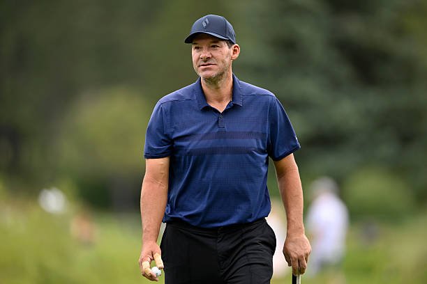 Tony Romo wearing a navy polo shirt and cap on the golf course at the American Century Championship.