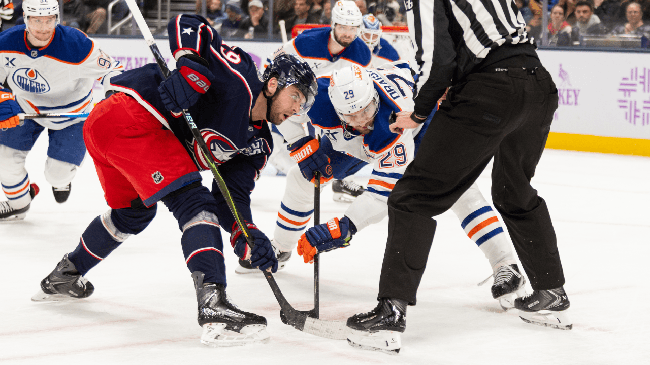 Columbus Blue Jackets and Edmonton Oilers players take a faceoff.