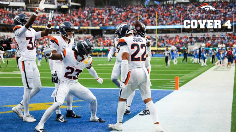 Denver Broncos defenders celebrate together in white uniforms during the October 11 game at the Los Angeles Chargers.