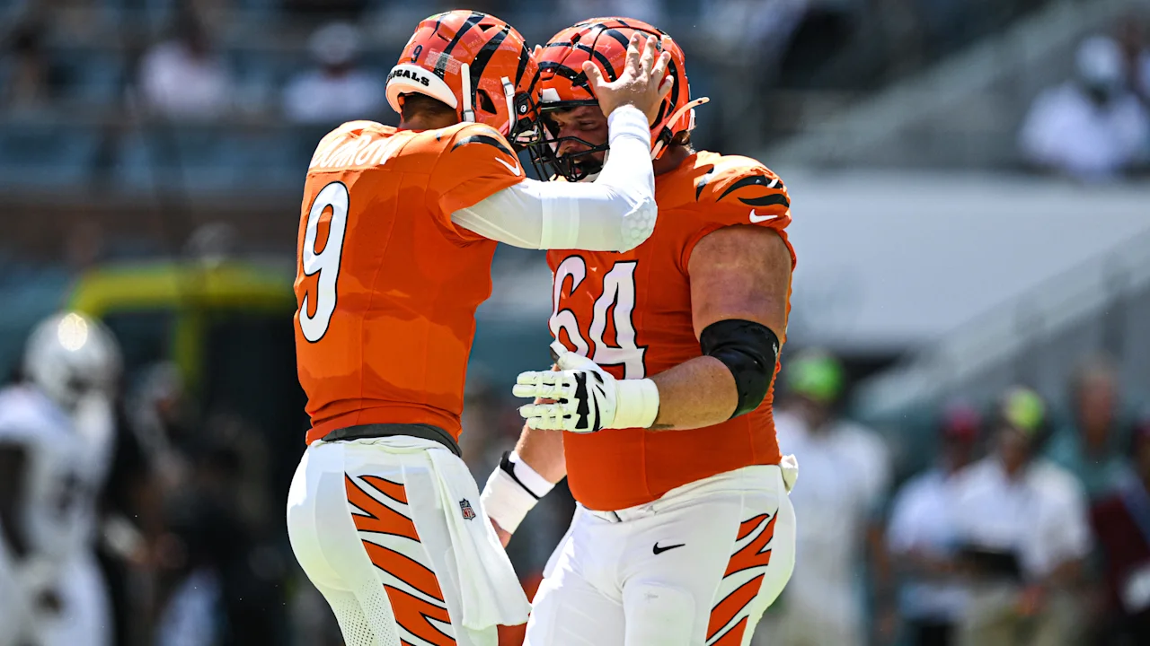 Joe Burrow and Ted Karras celebrate a touchdown in orange Bengals uniforms against Miami on October 11, 2026.