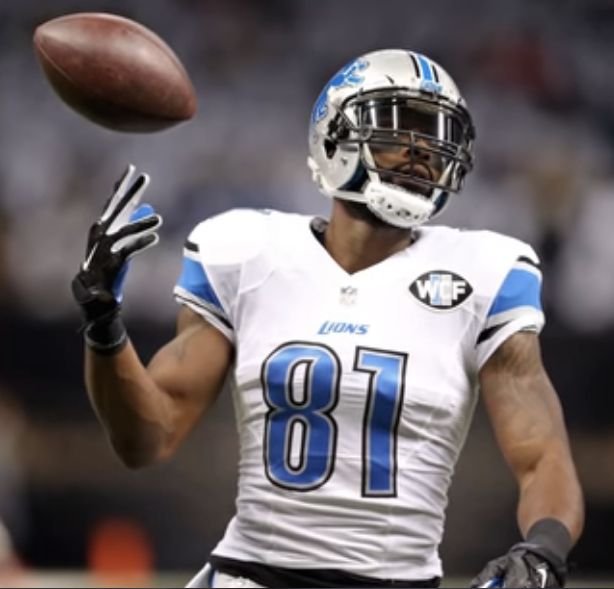 Calvin Johnson in a white Detroit Lions number 81 uniform looking toward a football.