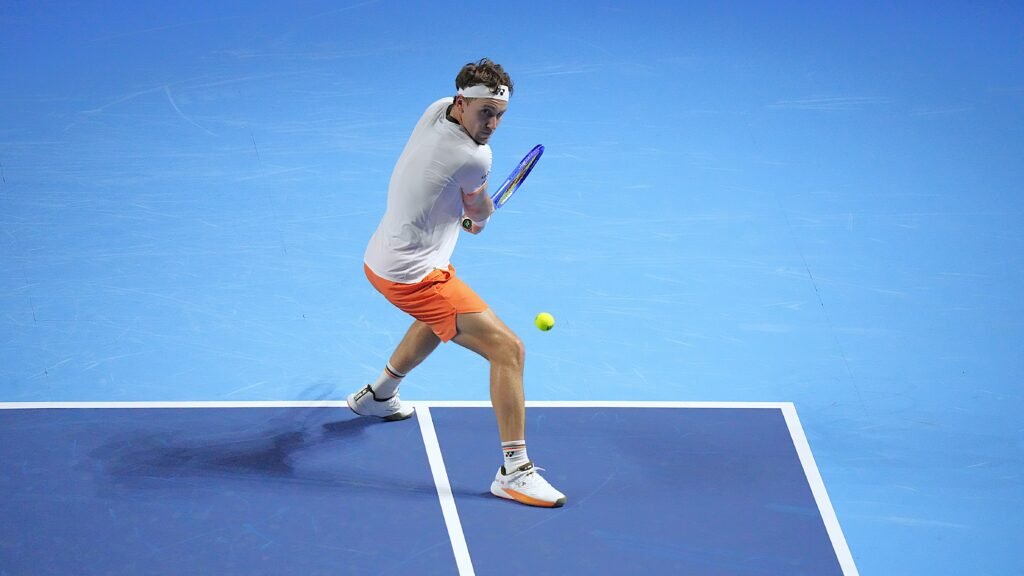 Casper Ruud plays a shot on an indoor blue tennis court in Basel on October 22, 2025.