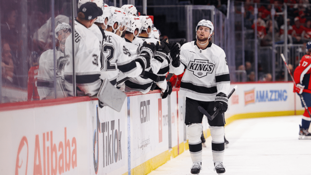 A Kings player exchanges glove taps with teammates on the bench in Washington.