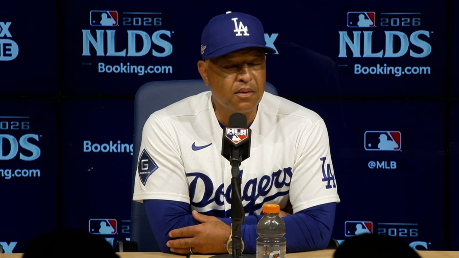 Dave Roberts speaks at the podium after the Dodgers’ NLDS Game 1 win over the Braves.