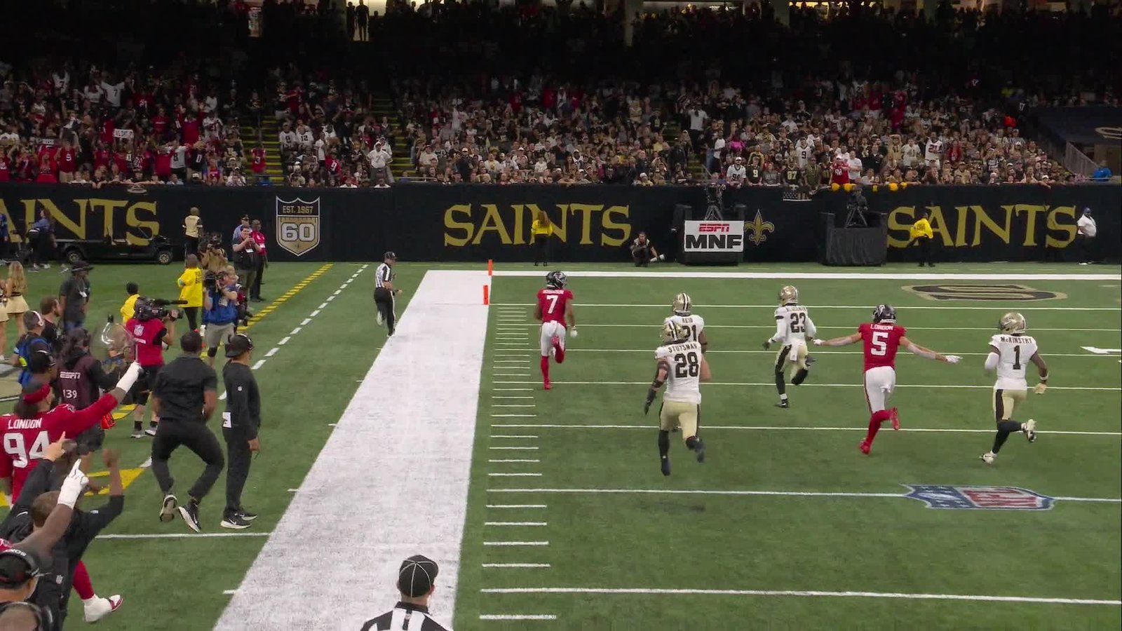 Atlanta running back Bijan Robinson runs toward the end zone with Saints defenders behind him.