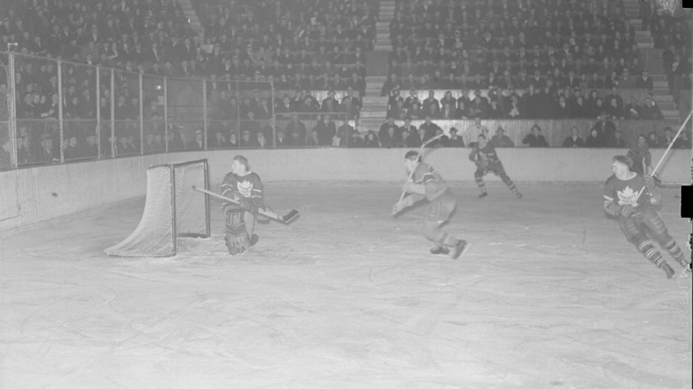 Players from the Montreal Canadiens and Toronto Maple Leafs around the goal during a 1938 hockey game.