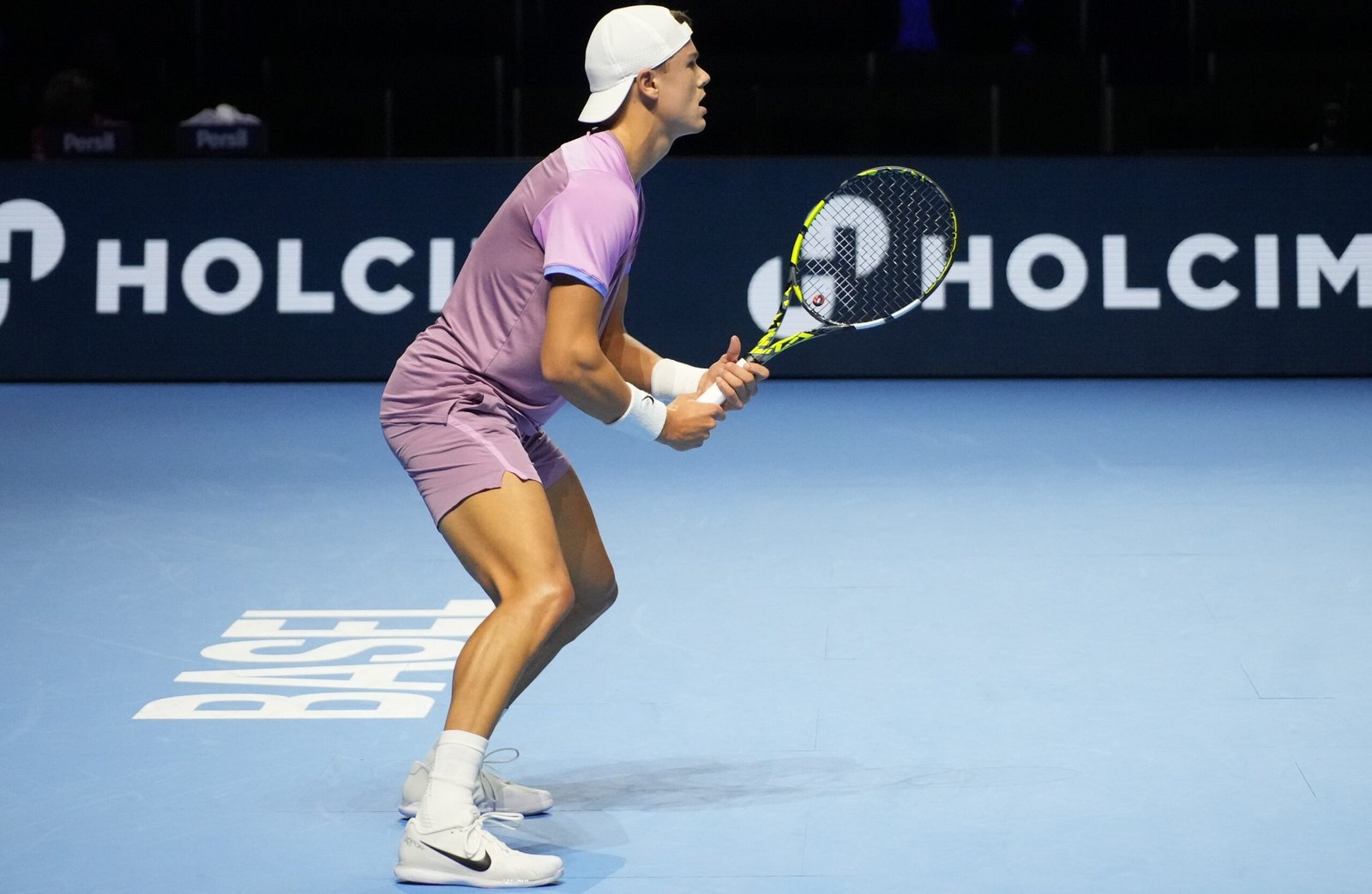 Holger Rune prepares to hit a shot on an indoor court at the 2024 Swiss Indoors.