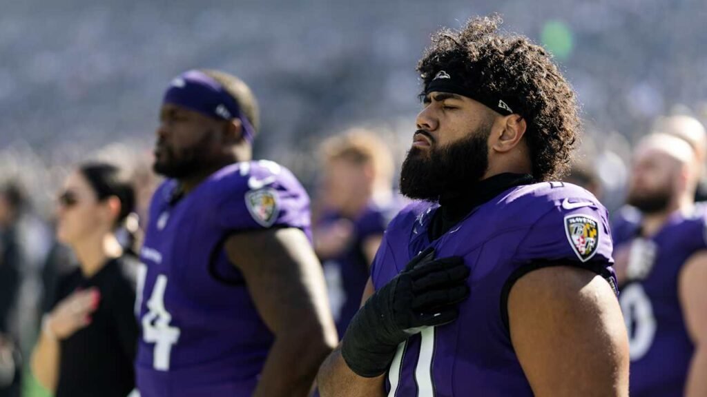 Vega Ioane on the Ravens sideline in a purple jersey.