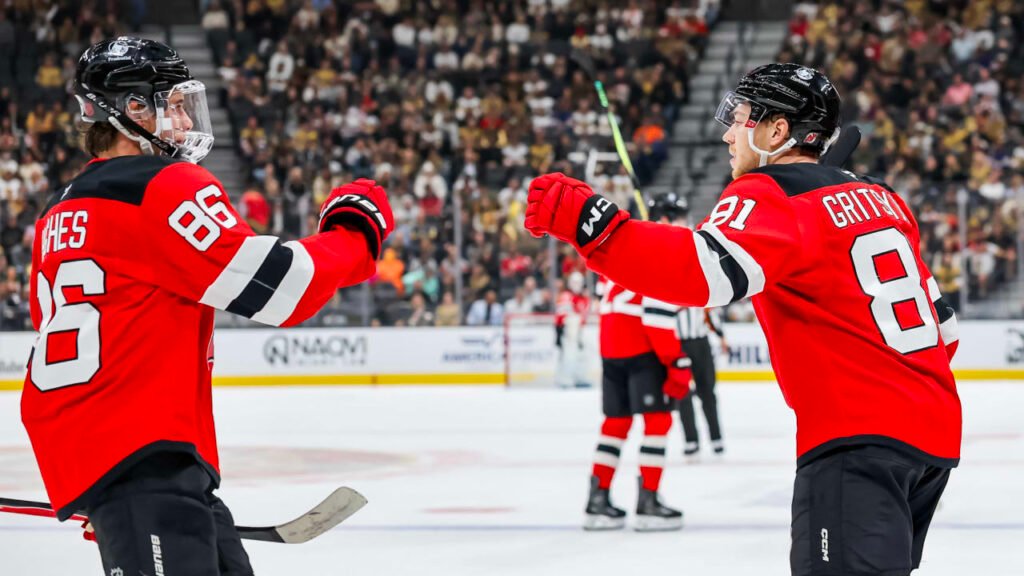 Jack Hughes and Arseny Gritsyuk exchange a glove tap during New Jersey’s October 30, 2026 game in Las Vegas.