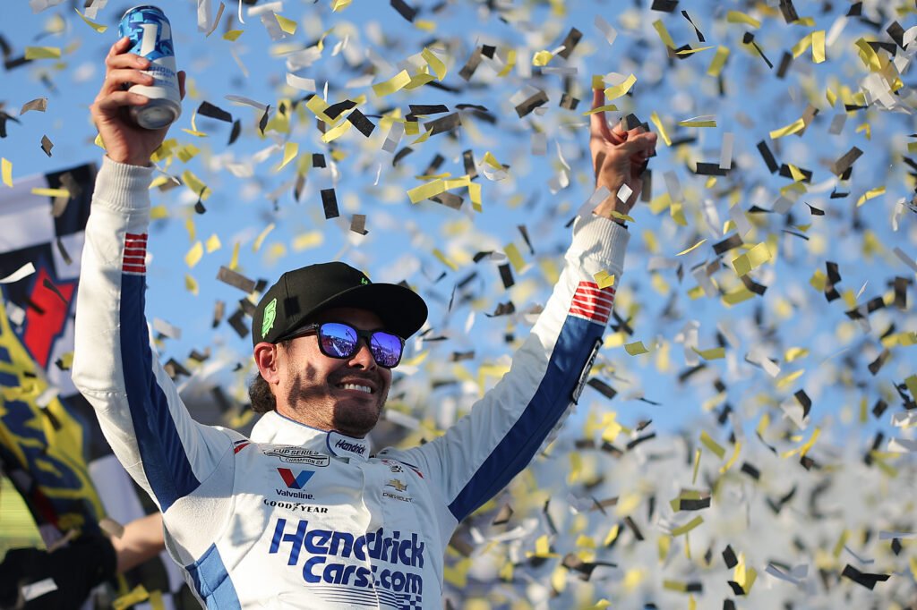Kyle Larson raises his arms amid confetti in Talladega’s victory lane.