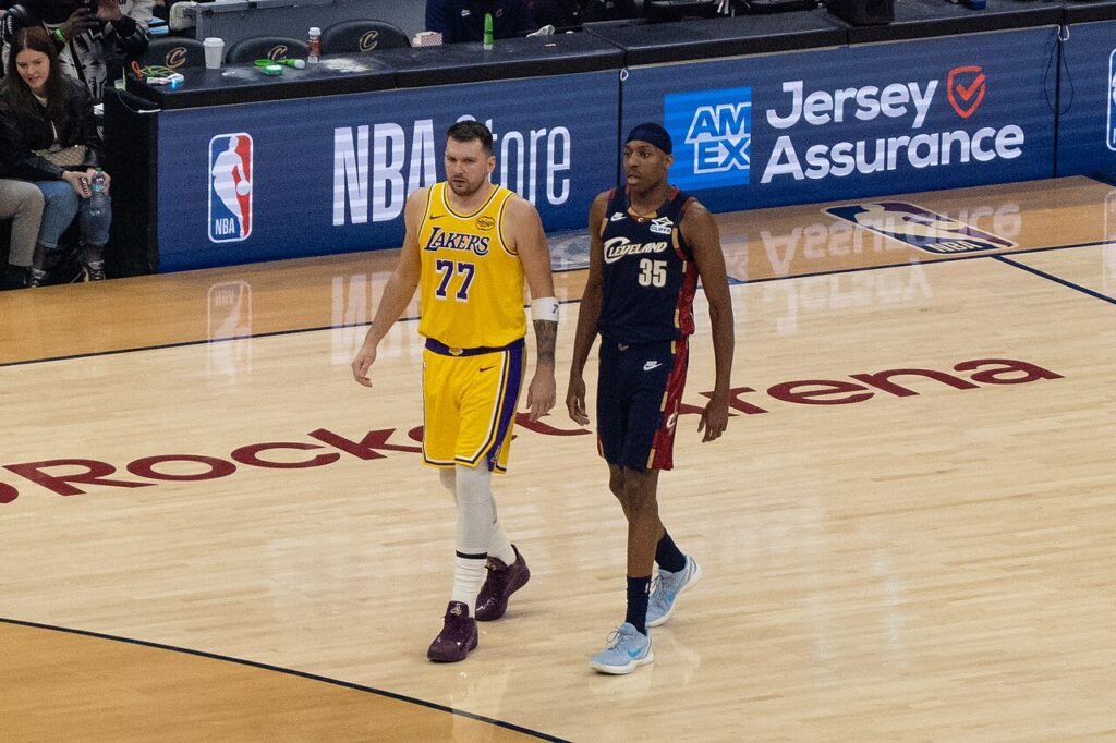 Luka Dončić in a yellow Lakers No. 77 jersey beside Cleveland’s Nae’Qwan Tomlin during their January 28, 2026 game.