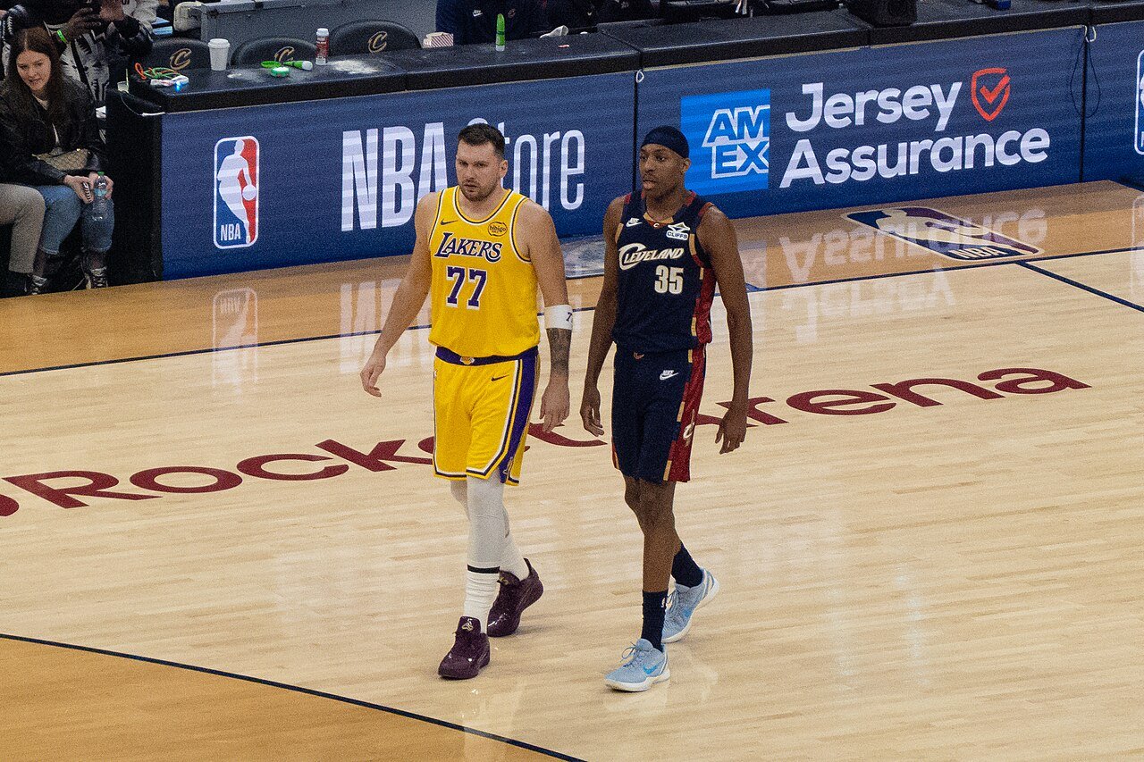 Luka Dončić in a yellow Lakers No. 77 jersey beside Cleveland’s Nae’Qwan Tomlin during their January 28, 2026 game.