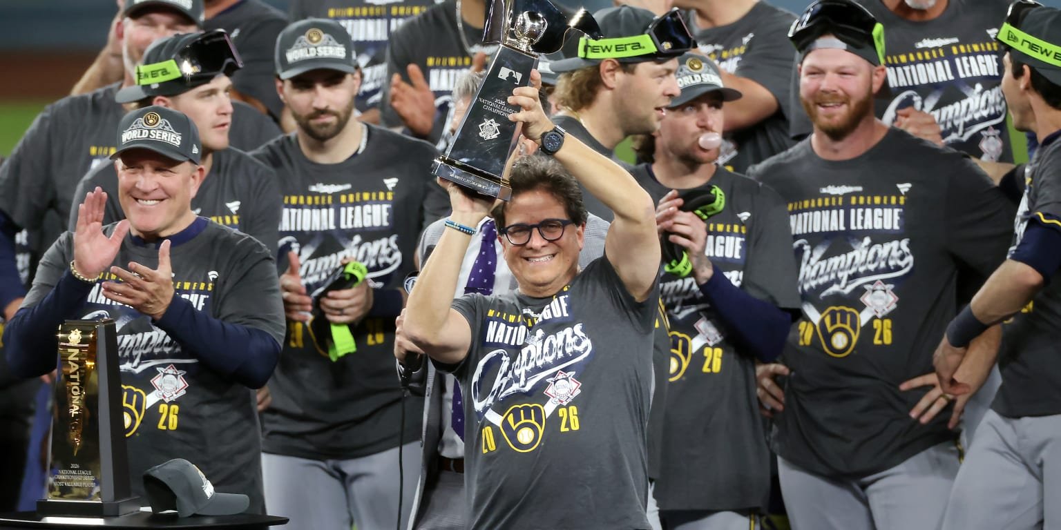 Mark Attanasio raises the National League championship trophy with the Brewers in October 2026.