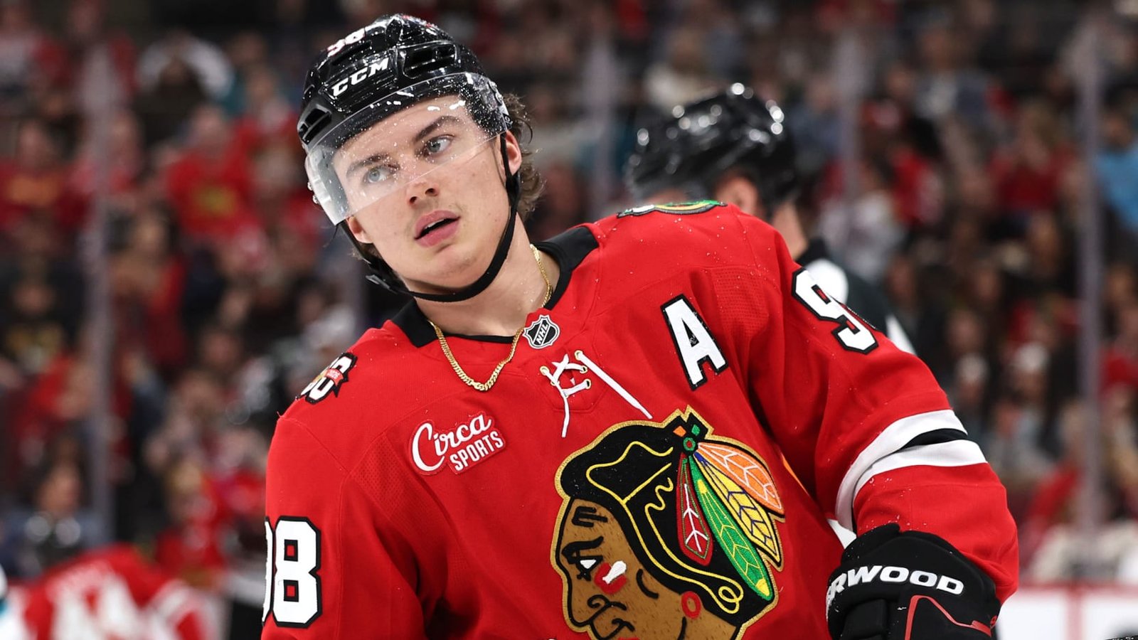Connor Bedard wearing a red Chicago Blackhawks jersey and black helmet.