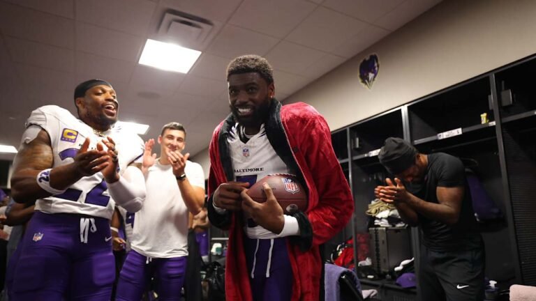 Tyler Huntley holding a football in the Ravens locker room after the Atlanta game.