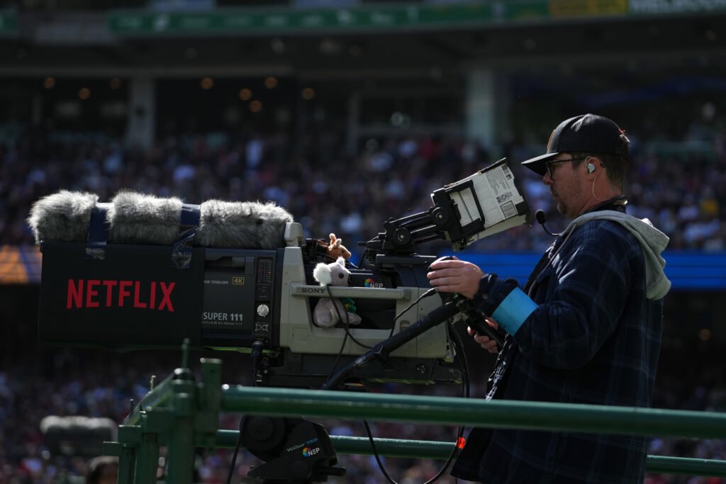 A camera operator works with a Netflix-branded television camera at Melbourne Cricket Ground.