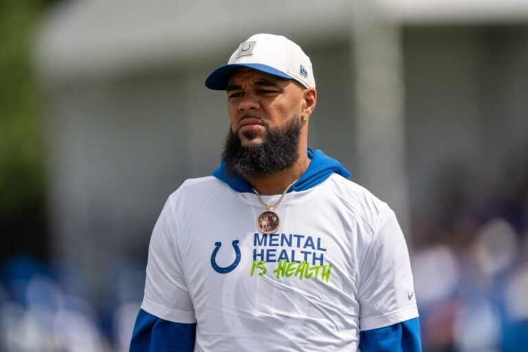 Keenan Allen wears a white Colts cap and team shirt outdoors.