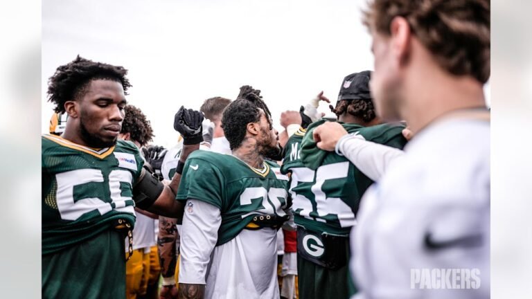 Edgerrin Cooper, No. 56, and Xavier McKinney, No. 29, stand with teammates at Packers practice.