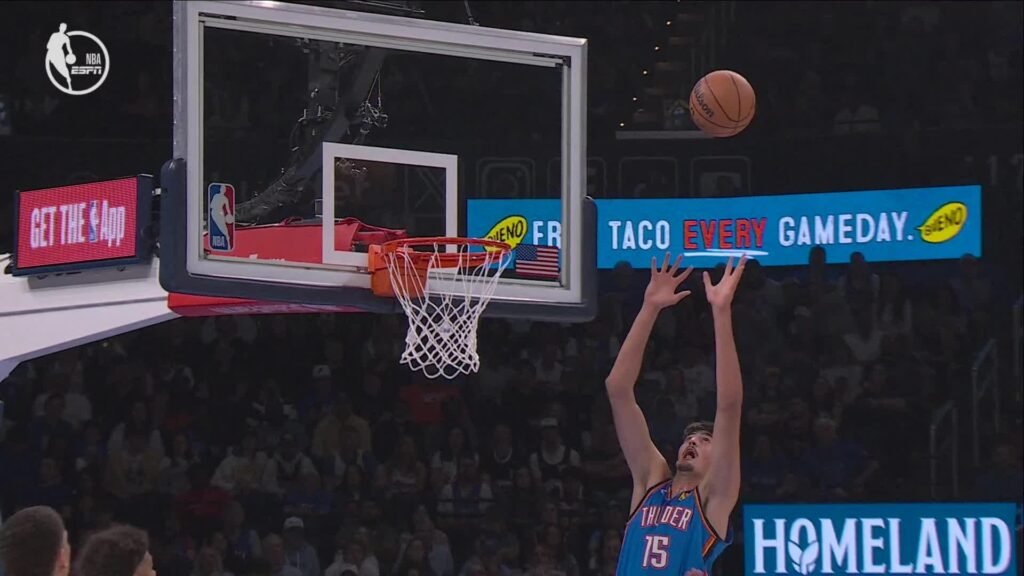 Oklahoma City center Aday Mara, wearing number 15, reaches toward the ball near the basket in an ESPN broadcast still.
