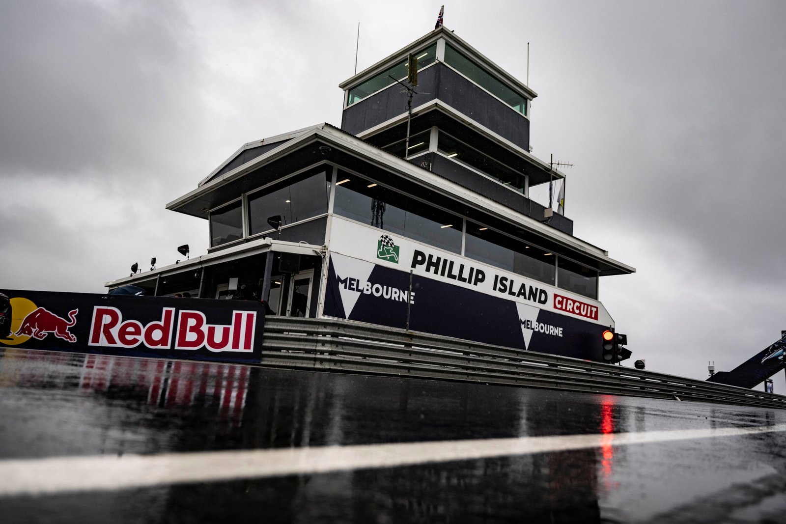 Rainwater covers the track in front of Phillip Island’s control tower under gray skies.