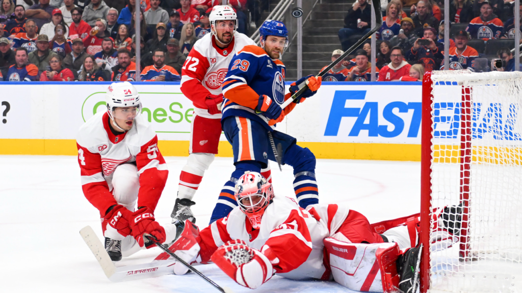 Detroit goalie Michal Postava makes a save with Leon Draisaitl in front of the net at Rogers Place.