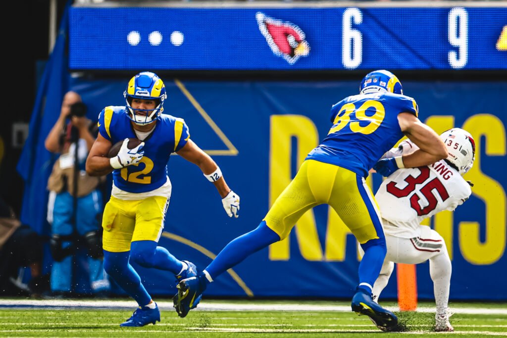 Puka Nacua carries the ball behind a Rams blocker against Arizona.